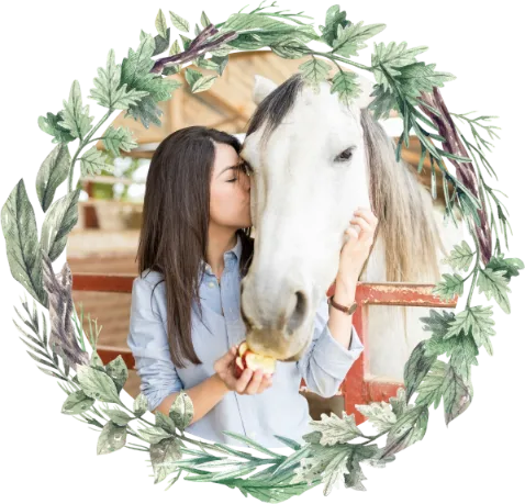 Woman lovingly kissing a horse while feeding it an apple, framed with natural greenery — representing trust, harmony, and homeopathy for horses.